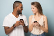 © fizkes - Happy African American man and Caucasian woman using phones