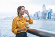 © BullRun - Pensive female blogger with caffeine beverage thoughtful looking away during Chinese holidays in Hong Kong, attractive young hipster girl pondering on international getaway for exploring world
