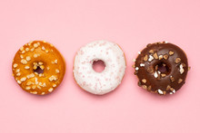 Sweet Chocolate, Caramel And Strawberry Donuts On Pink Background Flat Lay
