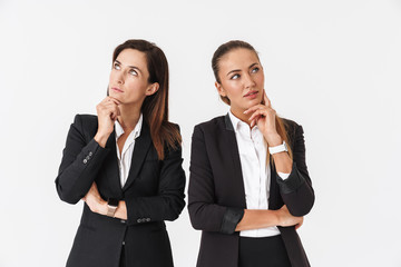 Wall Mural - Photo of thinking businesswomen posing and looking aside