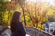 © svitlini - A young beautiful Caucasian girl with dark hair walks around the city and looks at the bright autumn trees in the park.