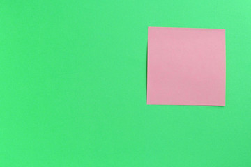 Wall Mural - Empty pink sticker note on a green background. Business concept, horizontal mock-up