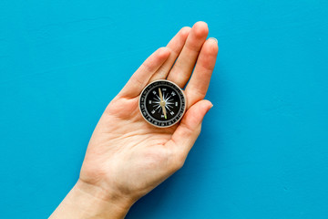 Wall Mural - Choose direction concept. Compass in hand on blue background top view copy space