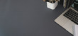 © bongkarn - Top view of modern workplace with laptop computer and office supplies on dark grey table