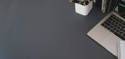 Canvas Print - top view of modern workplace with laptop computer and office supplies on dark grey table