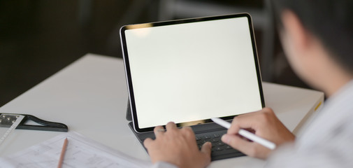 Wall Mural - Close-up view of young professional architect working on his project with mock up tablet in modern office