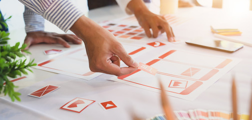 Cropped shot of professional UI web developer team working on smartphone application