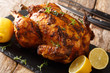 © FomaA - Freshly cooked rotisserie chicken with ginger and spices close-up on a slate board. horizontal