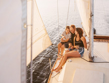 Happy Family Sailing On A Luxury Yacht Or Catamaran Boat