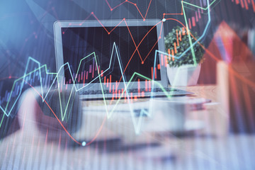 Stock market graph on background with desk and personal computer. Double exposure. Concept of financial analysis.