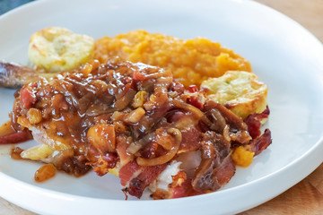 close up of Pheasant European dish traditional in November served with sweet sauce with dried raisin and fig with onion slice and potato.   