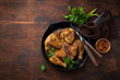 whole fried chicken tabaka on cast iron pan, old wooden background