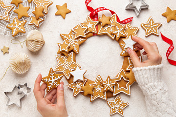 Wall Mural - Close up of female hands and Christmas   Gingerbread cookies wreath