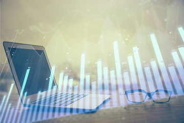 Stock market graph and table with computer background. Double exposure. Concept of financial analysis.