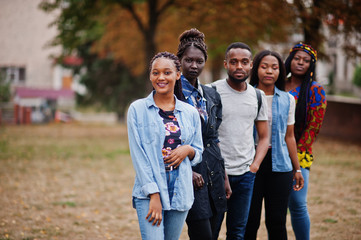 Wall Mural - Row of group five african college students spending time together on campus at university yard. Black afro friends studying. Education theme.