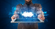 © ra2 studio - Hand holding tablet with cloud technology and dark concept