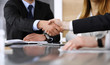 © Iryna - Businessman shaking hands with his colleague or partner above the glass desk in modern office, close-up. Unknown business people at meeting. Teamwork, partnership and handshake concept