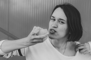 Black and white shot of Cute girl eating fresh lemon.