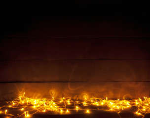 Wall Mural - The beautiful blurred christmas background with a lot of yellow lights on the wooden desk