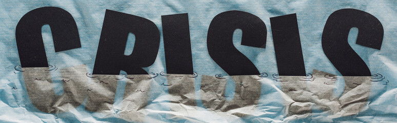 Poster - panoramic shot of black word crisis sinking in paper symbolizing water on grey paper background