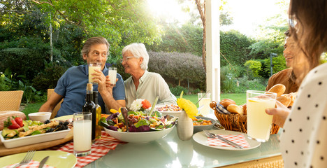 Wall Mural - Family eating outside together in summer