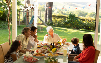 Wall Mural - Family eating outside together in summer