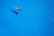 © vladstar - View from the top as a woman in a red swimsuit lying on her back in the pool. Relaxing concept