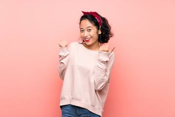 Wall Mural - Asian young woman over isolated pink background with thumbs up gesture and smiling