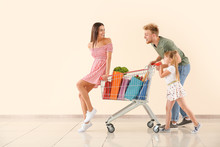 Family With Shopping Cart Near Light Wall