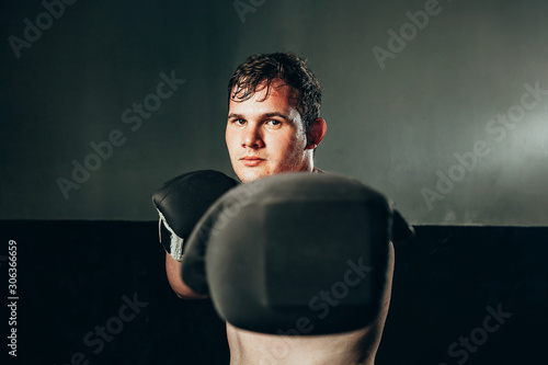 фотографія Portrait of male boxer punching in the gym