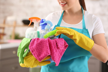 Poster - Female janitor with cleaning supplies in kitchen, closeup