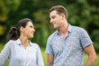 © FotoArtist - Outdoor shot of young couple in love joyful in the park through grass field. Man and woman hugging and  Laugh on grass field.