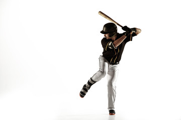 Baseball player, pitcher in a black uniform practicing and training isolated on a white background. Young professional sportsman in action and motion. Healthy lifestyle, sport, movement concept.