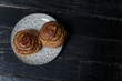 © elenaseiryk - Cheese and dill bread buns on plate standing on black wooden background. Tasty unhealthy food. Diet, nutrition, eating habits concept. Place for text.