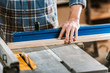 © LIGHTFIELD STUDIOS - cropped view of woodworker holding plank near circular saw