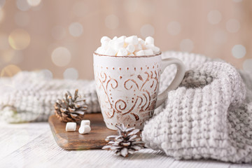 Mug with coffee and marshmallow, sweater, cinnamon. Cozy christmas composition. Hygge concept Soft focus