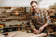 © LIGHTFIELD STUDIOS - happy bearded carpenter carving wood in workshop