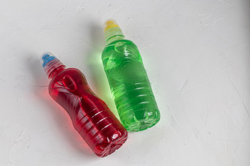 Fresh, fruit fluid for a healthy diet. Isotonic, energy drink. Two bottles with colorful water, a sports drink. Supports water balance. Copy space.	