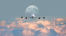 White Passenger Airplane In The Clouds With Full Moon - Travel By Air Transport "Elements Of This Image Furnished By NASA"