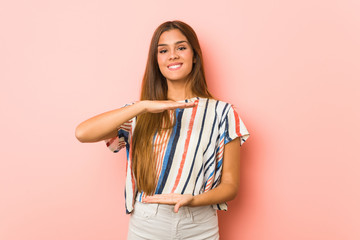 Young slim woman holding something with both hands, product presentation.