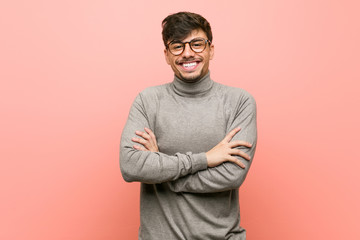 Young smart student man who feels confident, crossing arms with determination.