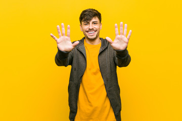 Wall Mural - Young hispanic casual man showing number ten with hands.