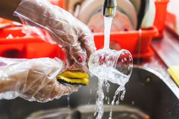 Housewife washes dishes under running water