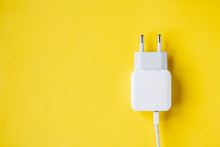 Mobile Charger And USB Cable On Yellow Background. Top View. Copy, Empty Space For Text