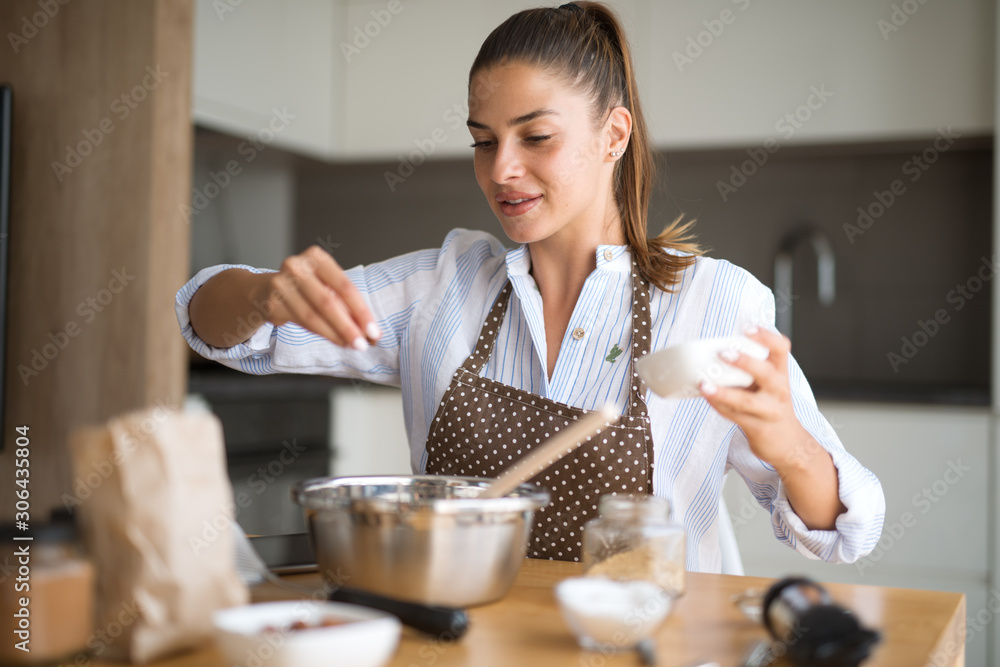 Young woman in kitchen preparing lunch - obrazy, fototapety, plakaty 