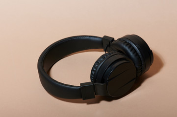 One black headphones lay on background