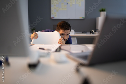 Fotomural Frightened Businessman Hiding Behind Chair