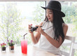 © Phuttharak - Beautiful Asian tourist woman wearing black hat  sitting in coffee shop with red drink on table