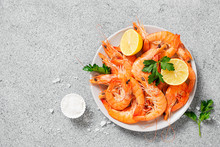 Steamed shrimps with lemon and herbs. Seafood, shellfish. Shrimps prawns on plate.