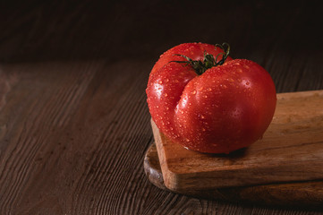 Close up macro image of a red ripe tomato on a dark background